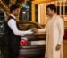 Valet attendant in uniform receiving car keys from a guest at a decorated wedding venue entrance in Bangalore